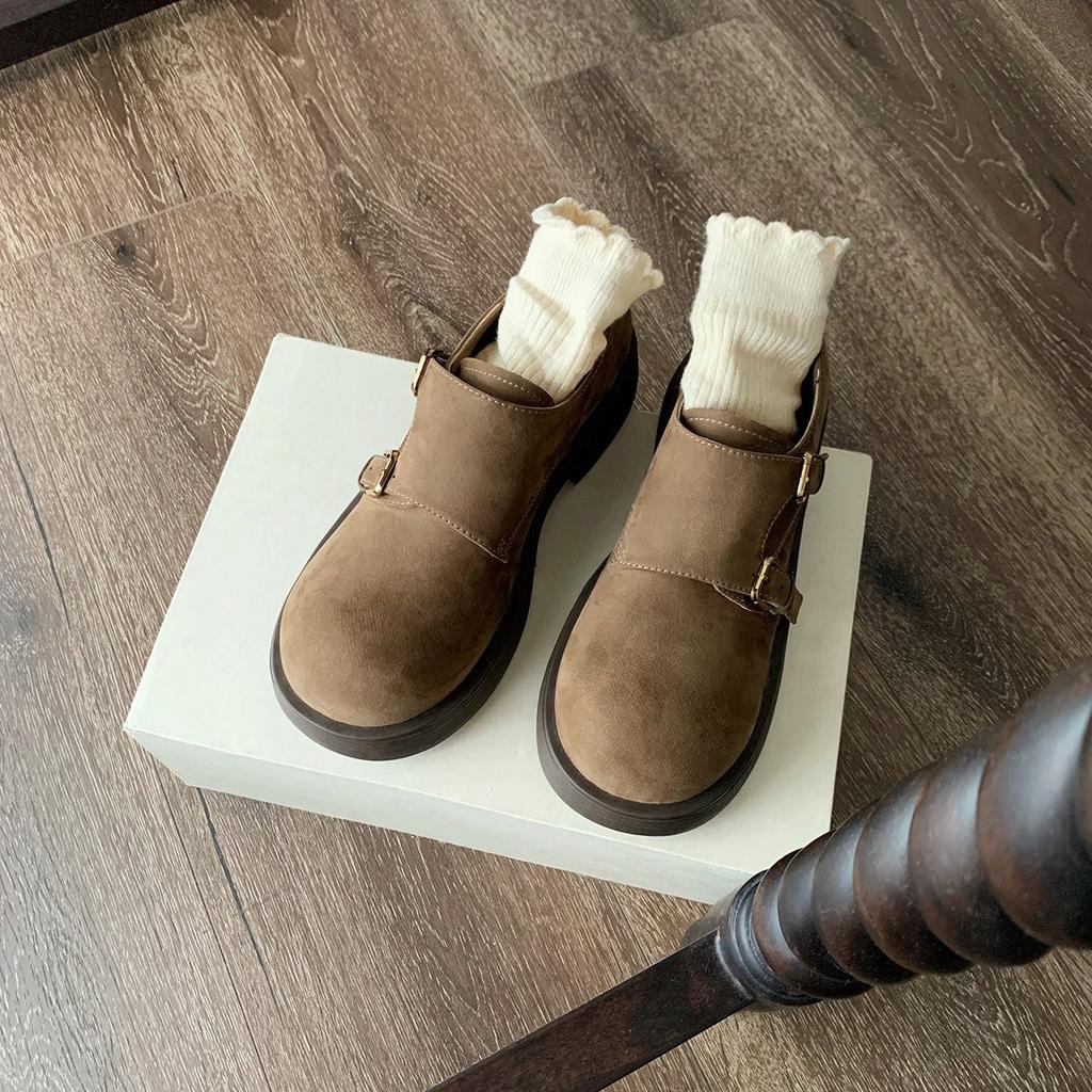 Eine Frau trägt ein Paar Retro-Schuhe mit großen Köpfen, runder Zehenpartie und rutschfesten Sohlen.