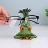 Niedlicher Brillenhalter-Ständer in Froschform. Dekorativer Brillenhalter-Ständer in Froschform zur sicheren Aufbewahrung von Brillen auf dem Schreibtisch.