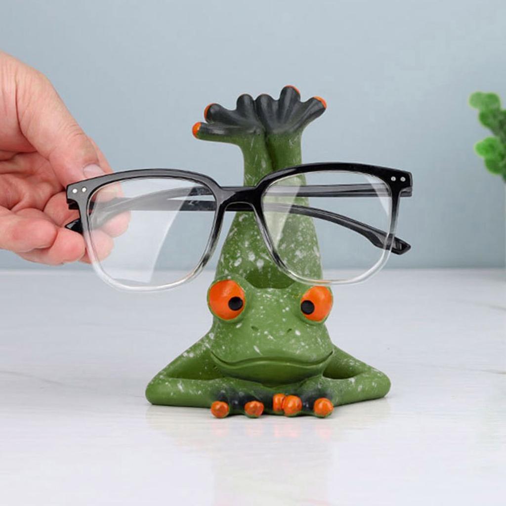 Niedlicher Brillenhalter-Ständer in Froschform. Dekorativer Brillenhalter-Ständer in Froschform zur sicheren Aufbewahrung von Brillen auf dem Schreibtisch.