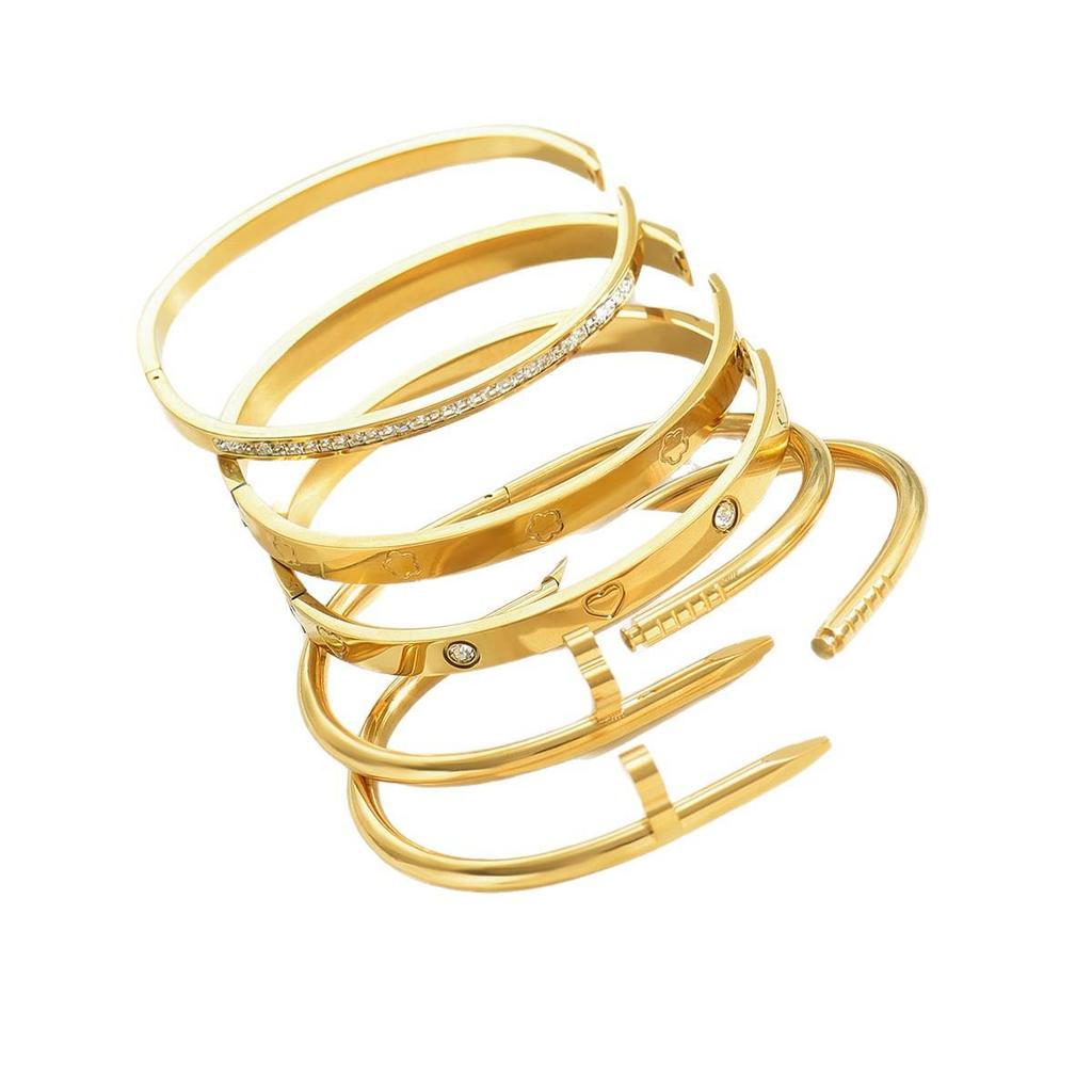 Zestaw bransoletek ze złota i stali nierdzewnej z ćwiekami wysadzanymi diamentami, akcentami gwiazd i bransoletkami z czterolistną koniczyną.