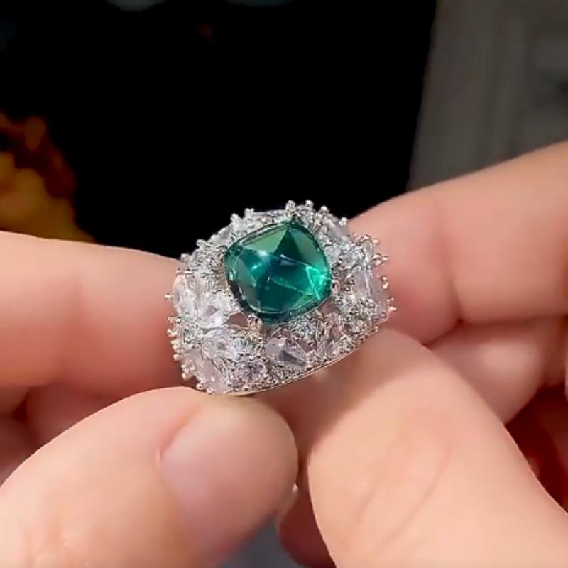 Luxurious geometric ring with bright green zircon and sparkling zirconia floral design in the center