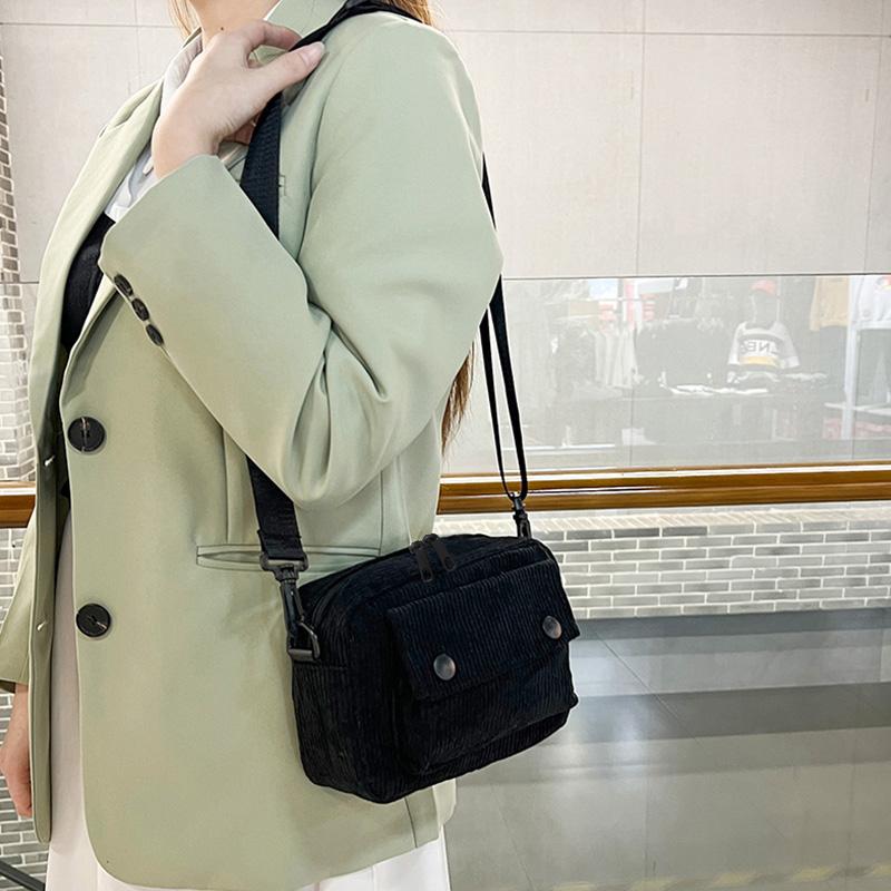 Neutral men's and women's cross-body bag with shoulder strap, made of corduroy material, with a flap design  the outside.