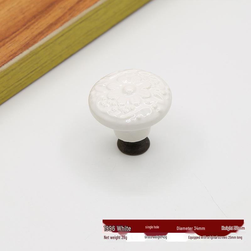 Antikt vit keramiskt lådhandtag med präglad blomdesign