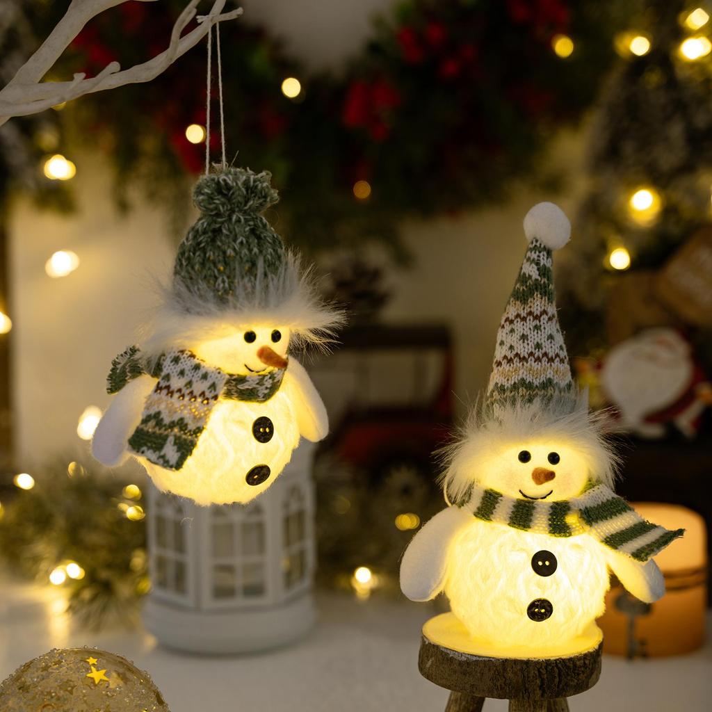 Weihnachts-Schneemann-Dekoration mit grüner Strickmütze und Lichtern