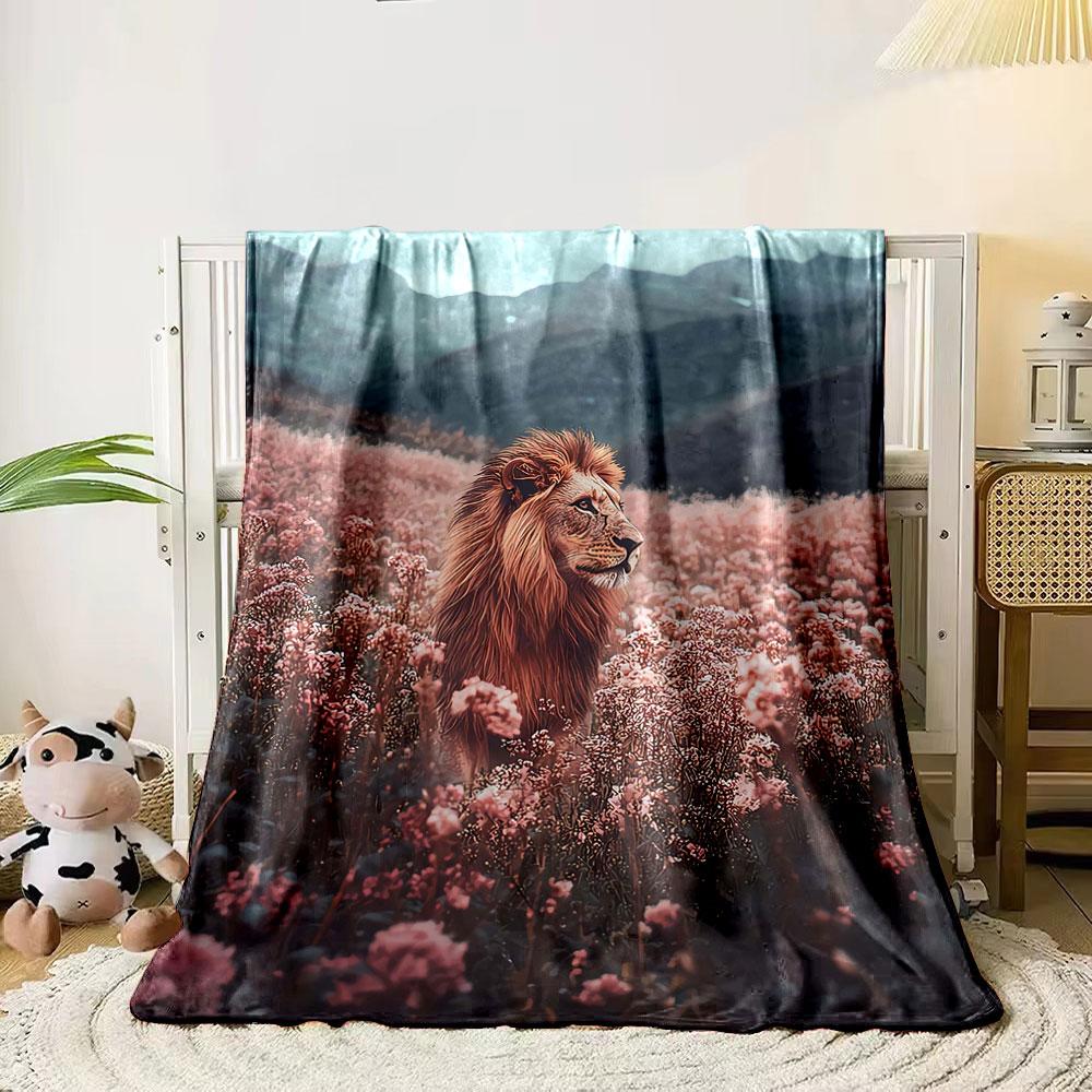 A lion stands in a field of pink flowers with mountains in the background. for all seasons blanket lunch break throw gift 80cm x 120cm