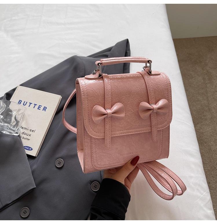 

Корейская версия универсальной портативной женской сумки 2025 лето новая сумка через плечо с бантом, маленький рюкзак с двойными лямками, нишевый дизайн розовый