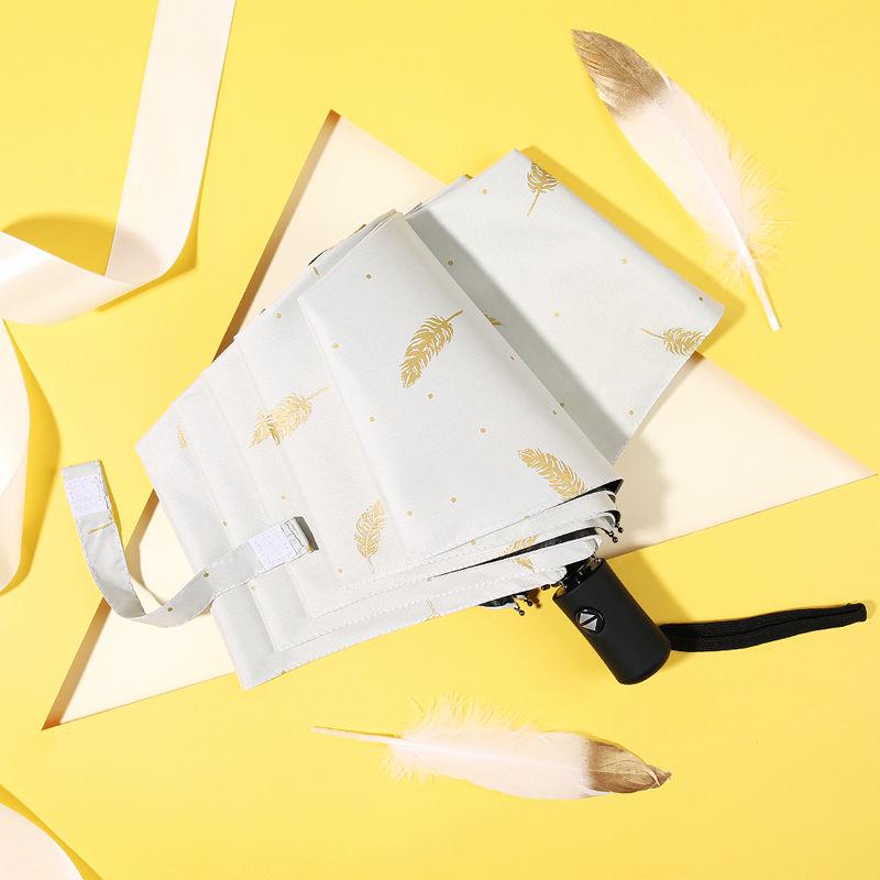 Kompakter, dreifach faltbarer Sonnen- und Regenschirm mit goldgeprägter Feder und UV-Schutz