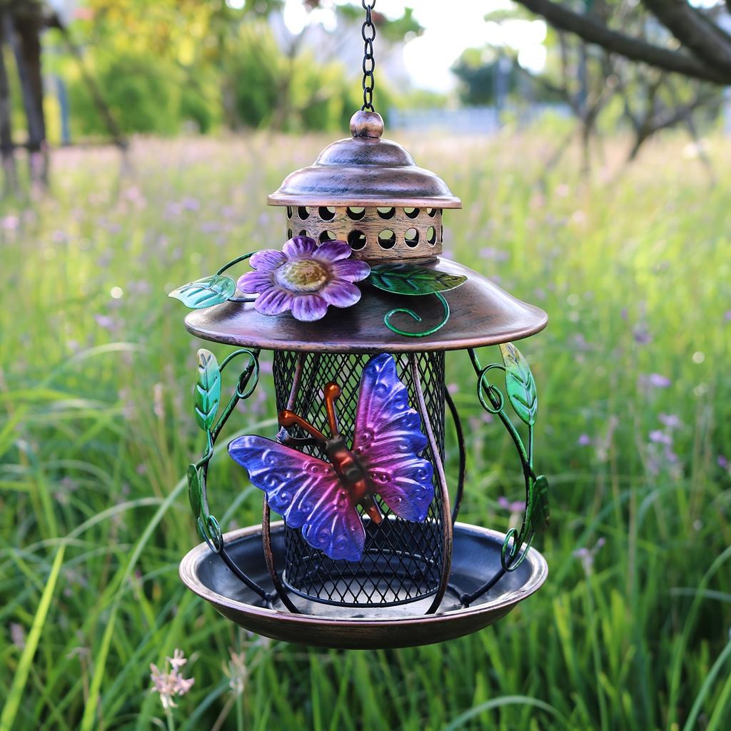 An outdoor hanging bird feeder with hooks and iron mesh, featuring decorative dragonfly and flower patterns, suitable for use in gardens or