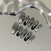 Skin-brightening grey press-on nails featuring detachable black Chrome Hearts-style crosses; entirely handmade.