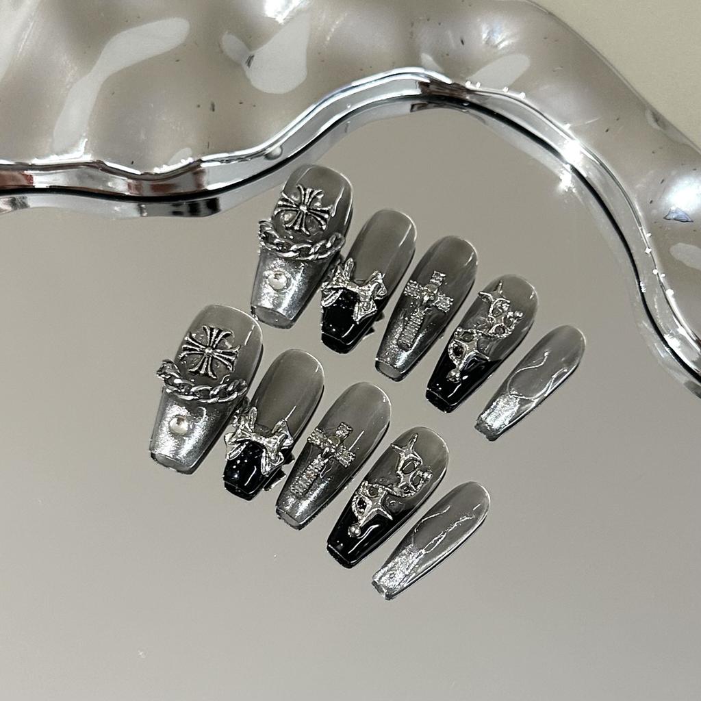 Skin-brightening grey press-on nails featuring detachable black Chrome Hearts-style crosses; entirely handmade.