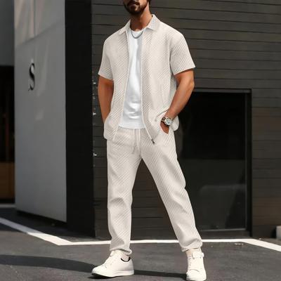 Pánská bunda s krátkým rukávem a kalhoty s geometrickým potiskem a bílé tričko, ležérní streetwearový outfit