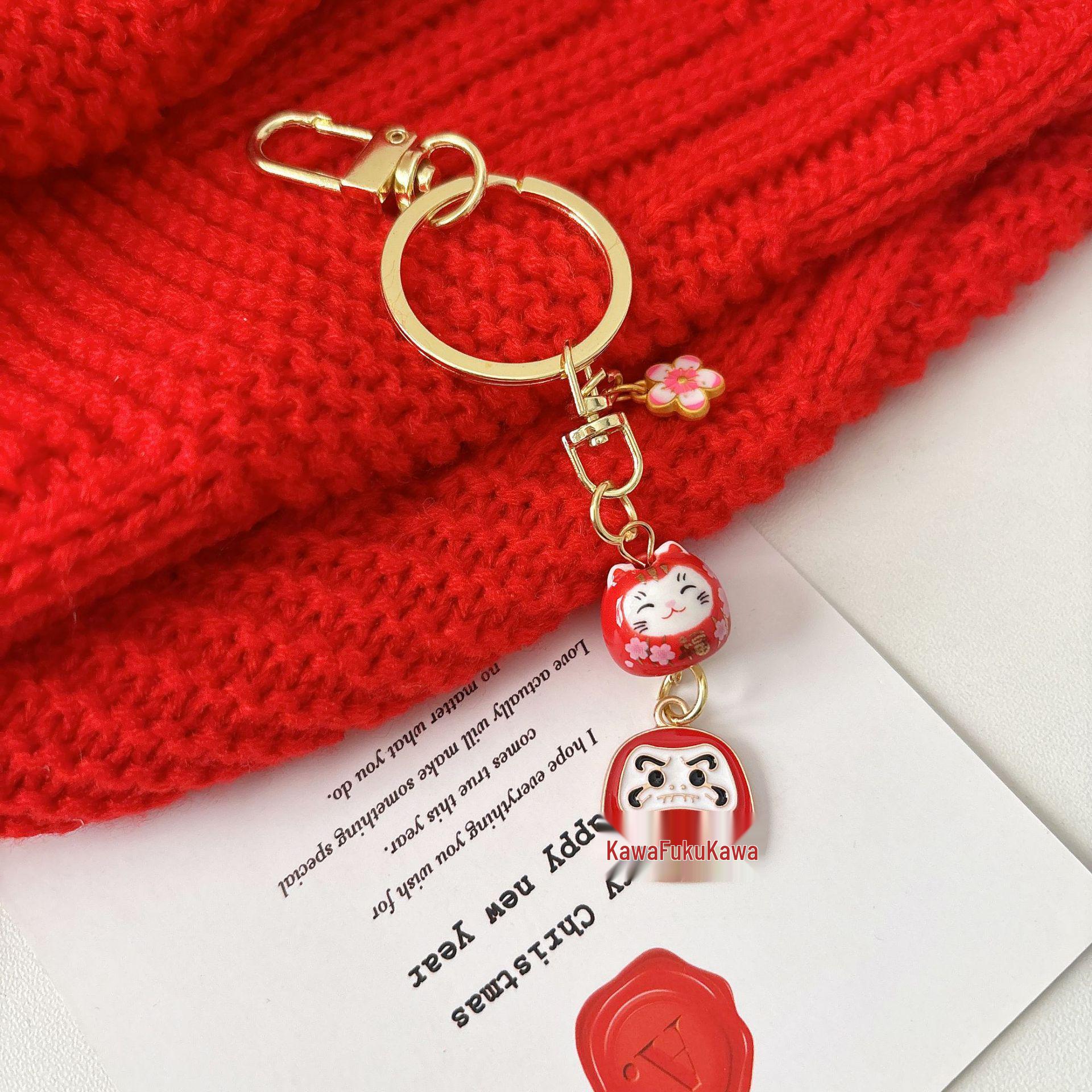 Pink Daruma Cat Charm: Auspicious Ceramic Pendant for Promising Future, Peace, and Joy.