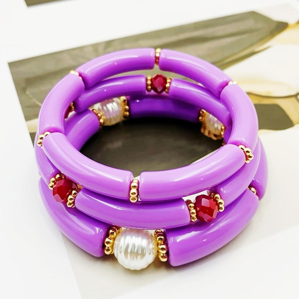 A set of three acrylic tubes connected by small golden flowers, adorned with crystal and faux pearl decorations, suitable for a lady's party.