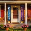 Halloween flags decorate the courtyard for an outdoor party. Cartoon doors hang with festive backdrop cloth. Halloween couplets.
