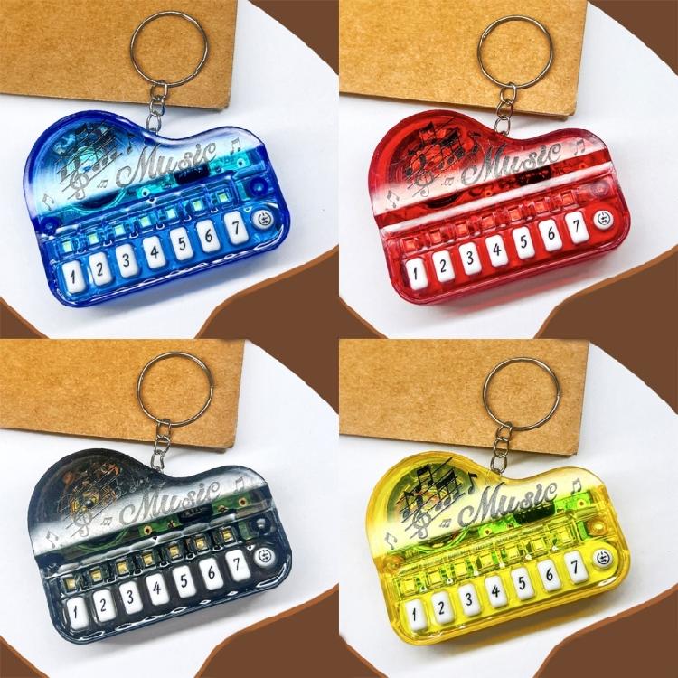Piano eletrônico de bolso em formato de chaveiro, com teclas iluminadas multicoloridas, dispositivo portátil para aprendizado musical infantil.