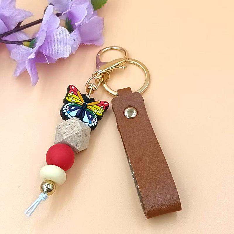 European & American Sweet Butterfly Daisy Silicone Beaded Keychain with Leather Bow Pendant