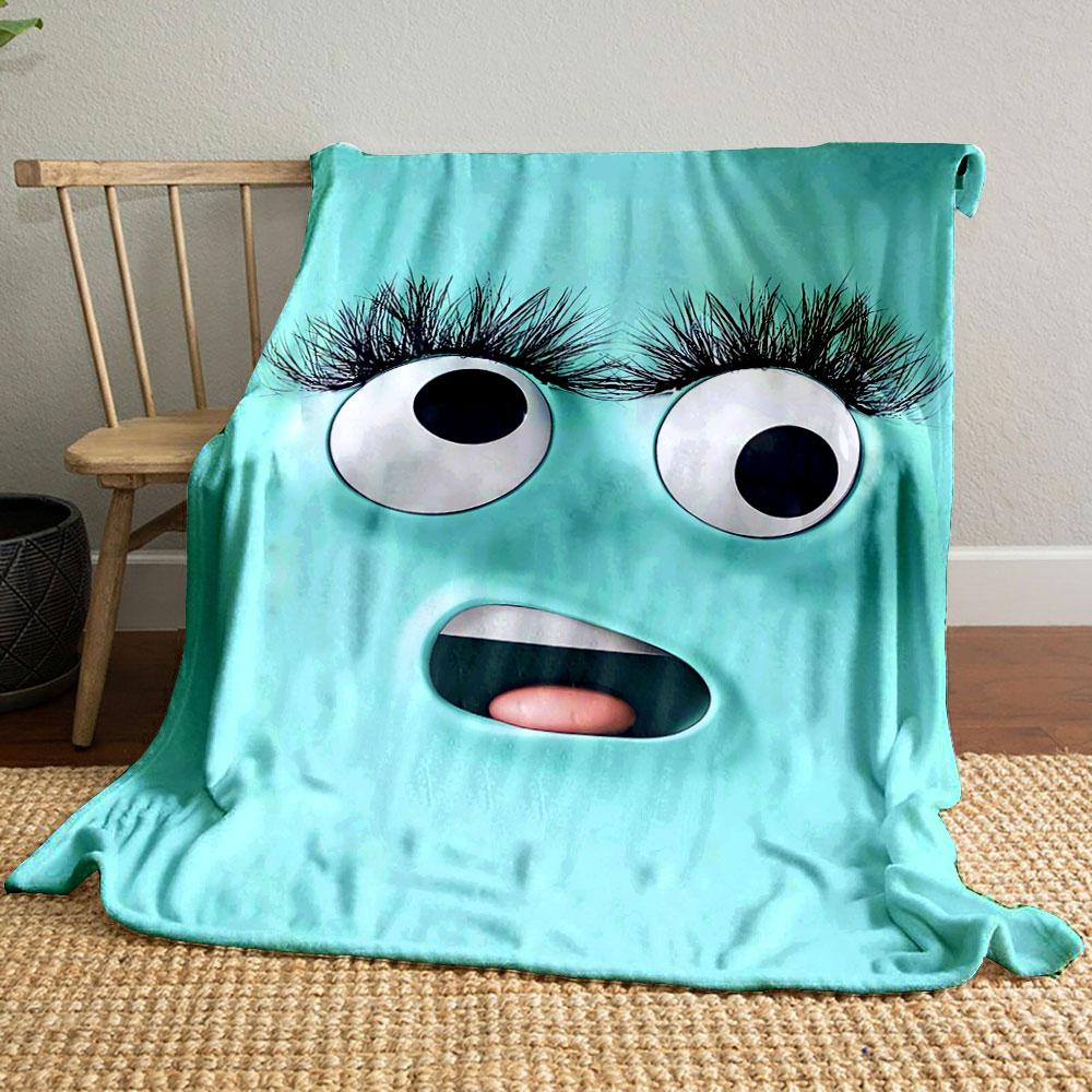 A playful turquoise face with large eyes, long lashes, and an open mouth. for all seasons blanket lunch break throw gift