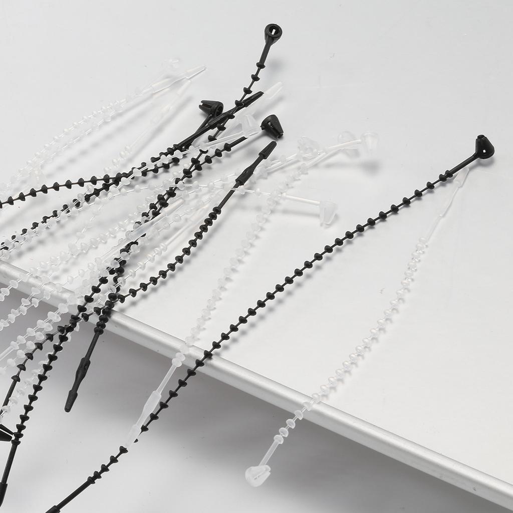 Schwarzes handgenähtes Fadenetikett mit einem Perlengarn, einer Gumminadel und Fadenetikett