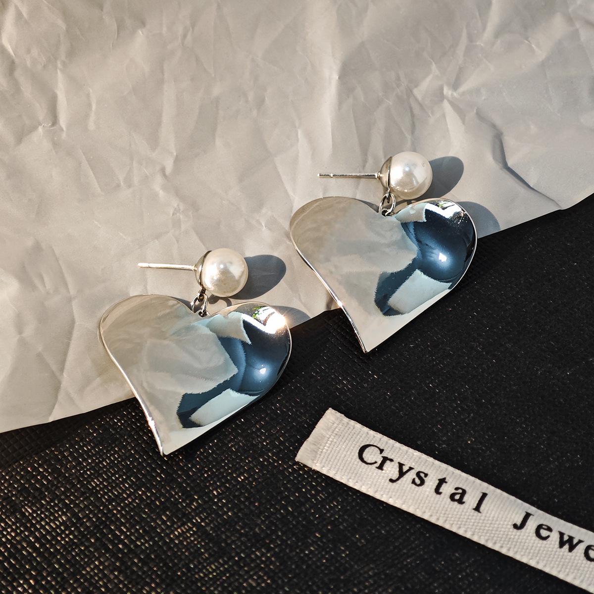 

Silver Needle Minimalist Heart Dangle Earrings: Light Luxury Metal and Pearl Design for Women.