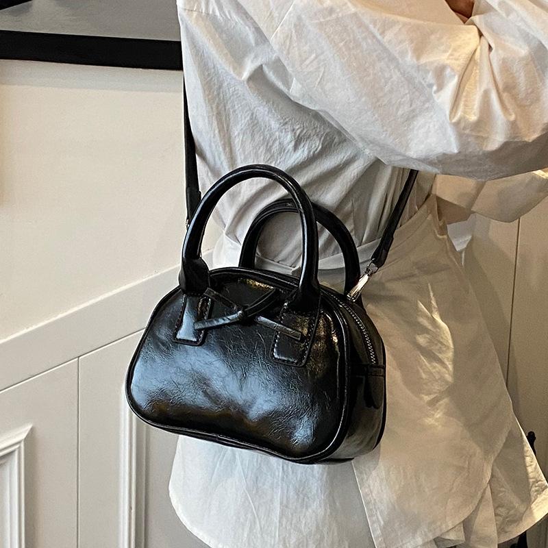 Südkoreas beliebte Nische einfache einfarbige tragbare Bowlingtasche Damen lässig ausländischer Stil hochwertige vielseitige Umhängetasche