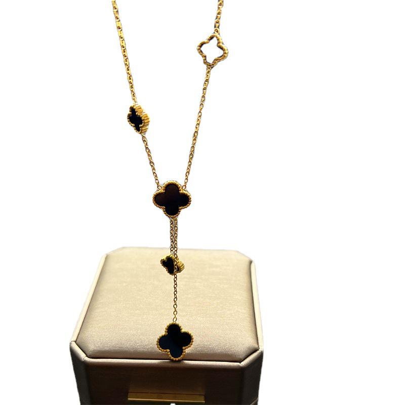 European & American Trendy Hollow Four-Leaf Clover Necklace with Black Shell Tassel Pendant.