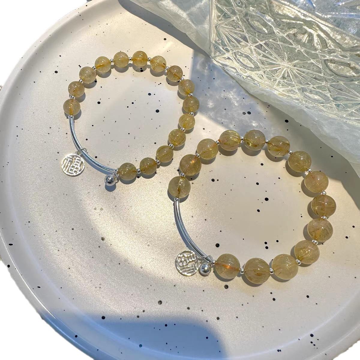 

Natural golden rutilated quartz crystal bracelet, versatile and unique, with a lucky charm and bell design, fresh and sweet style about8mm Crystal stone