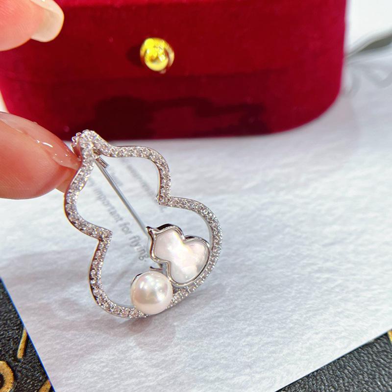 

Брошь в китайском стиле в виде полой тыквы-горлянки с ракушкой, медью, цирконом, толстым золотым покрытием и жемчужной корсажной брошью.