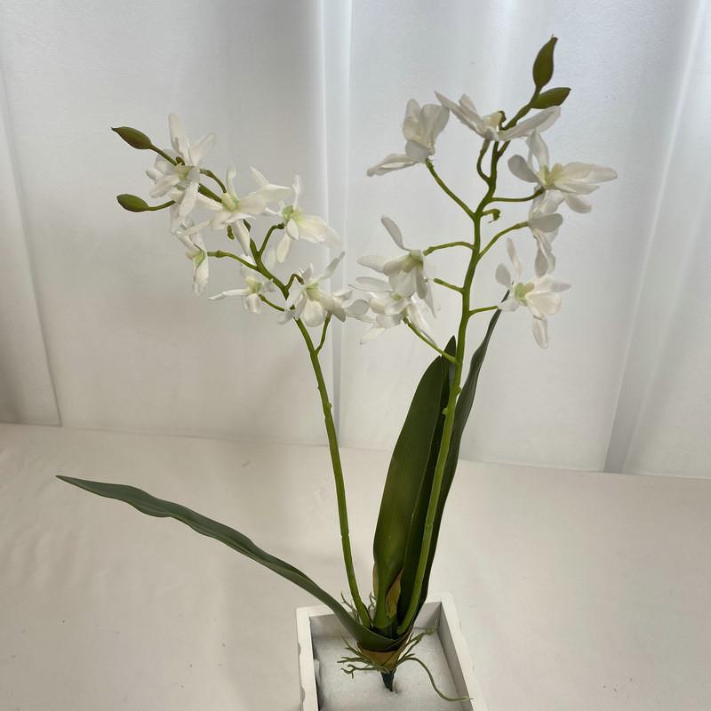Realistische Seiden-Dendrobium-Orchidee mit Blättern für Blumengesteck auf dem Esstisch
