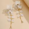 A pair of women's long earrings in bohemian style, made of acrylic with iridescent shells, flowers, and crystals, suitable as a holiday gift