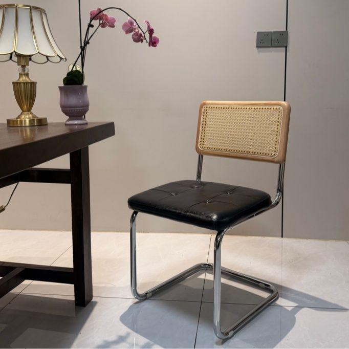 Elegantly crafted armless rattan dining chair in retro pastoral style, perfect for cafes, guesthouses, and vintage settings.