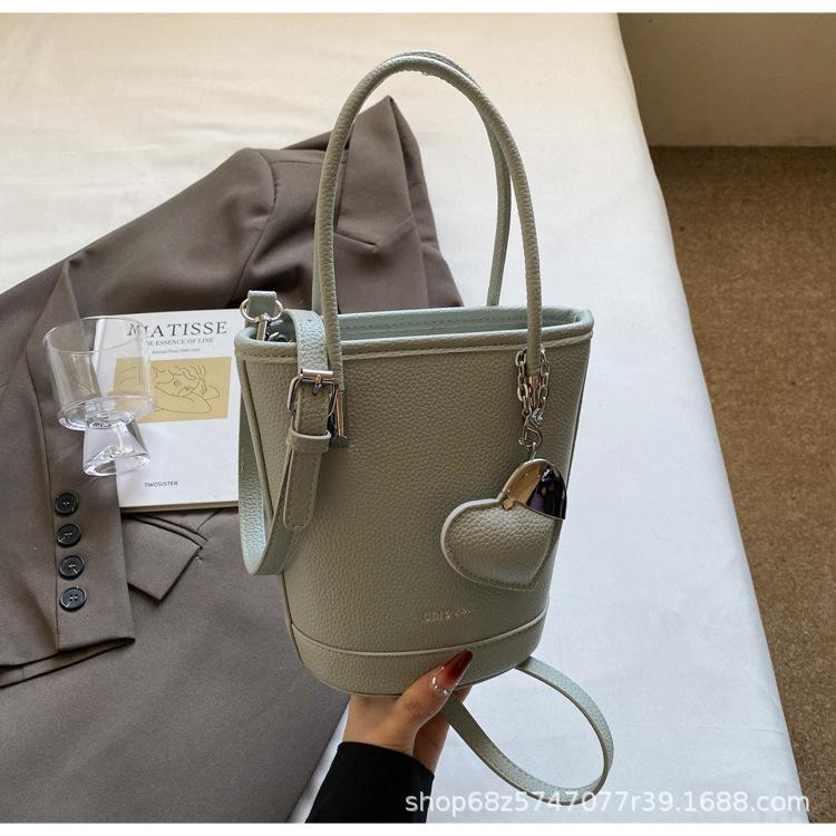 New niche simple solid color lychee pattern texture hand carrying bucket bag versatile foreign style commuting messenger women's bag