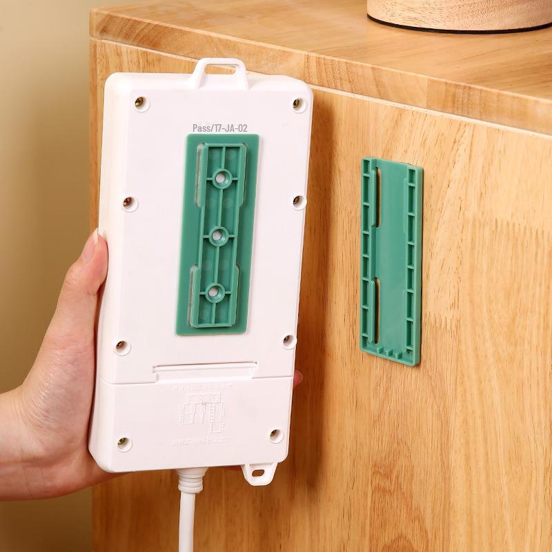 Nástěnný držák bez děrovače pro organizaci a vedení kabelů.