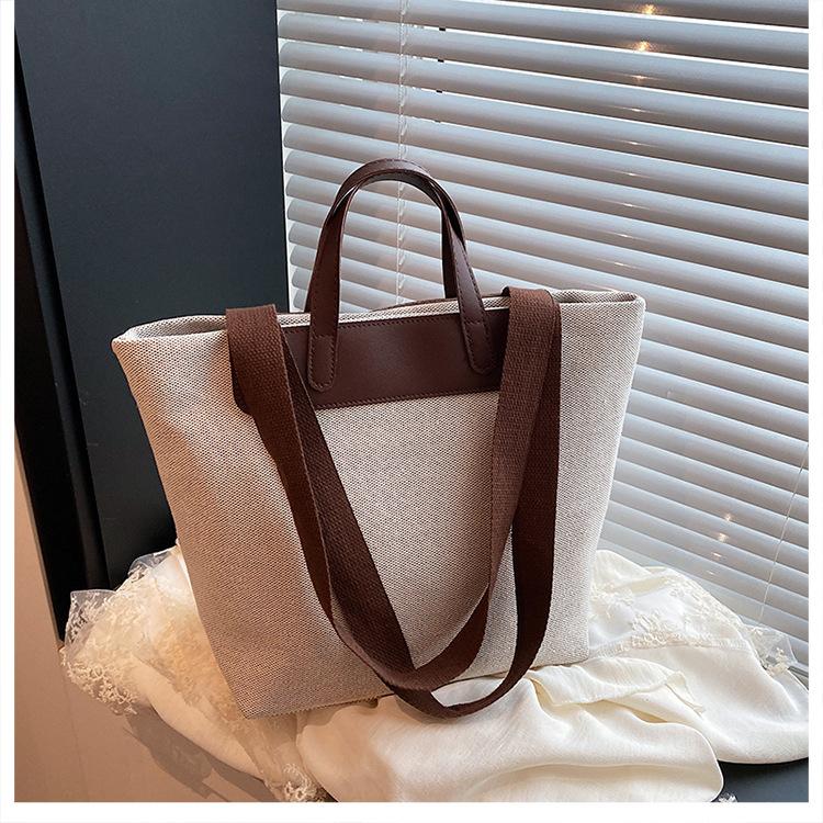 Fritid och konst splicing canvas 2025 vävning enkel ny temperament pendling mode tote bärbar axelväska