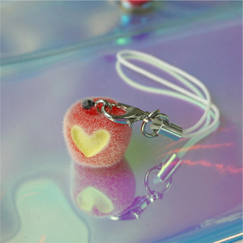 A sweet and sour apple keychain with a bite apple seeds