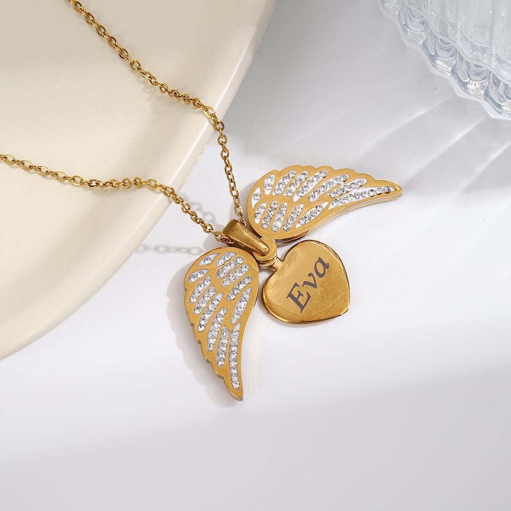 Kazılabilir Kalp Şeklinde Tasarım ve Melek Kanadı Aksanlarına Sahip Titanyum Çelik Kolye