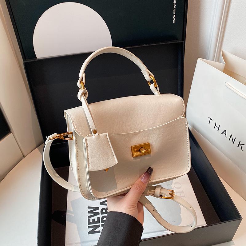 

В этом году популярная сумка-мессенджер на одно плечо выглядит модной и универсальной: мягкая кожа, переносной замок, небольшая квадратная сумка, удобная для поездок на работу белый