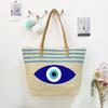 Umweltfreundliche Stroh-Schultertasche mit blauem Augen-Stickdesign für Sommerausflüge