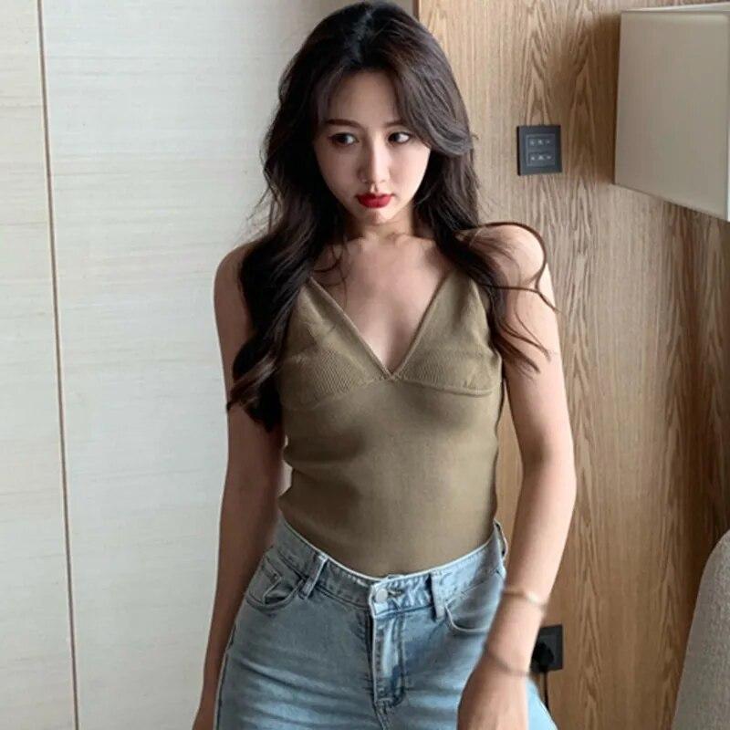 Tief ausgeschnittene Hosenträger mit tiefem V-Ausschnitt und kleine Weste. Frauen tragen ärmellose Oberteile