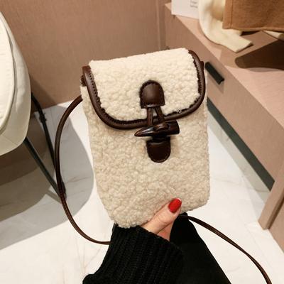 Die Handytasche ist in einer Kontrastfarbe, stilvoll, eine kleine Umhängetasche, und im Retro-Stil