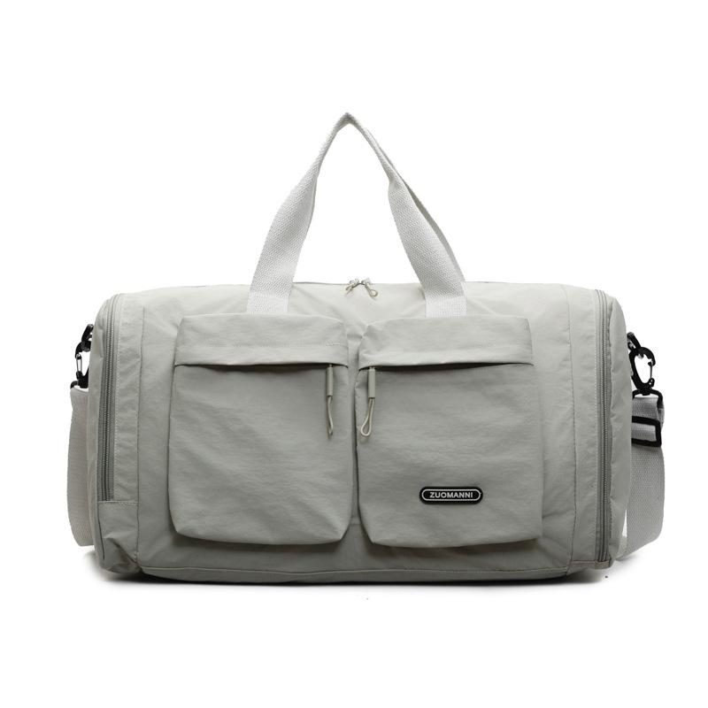 Trocken- und Nassfach Kurzreisetasche Damenhand legt eine Duffeltasche mit großem Fassungsvermögen und mehreren Fächern zur Aufbewahrung für schwangere Frauen zur Entbindung aus