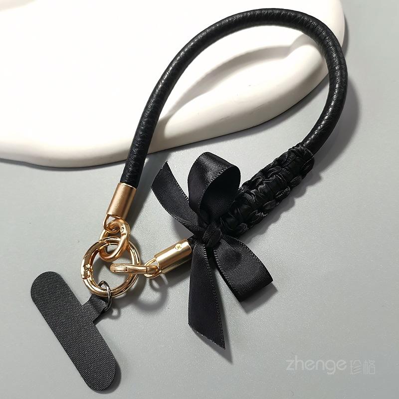 Bow leather mobile phone lanyard women s ins fashion small fragrance style hand-held wrist rope mobile phone case hanging rope short model [black bow] gold leather wrist rope