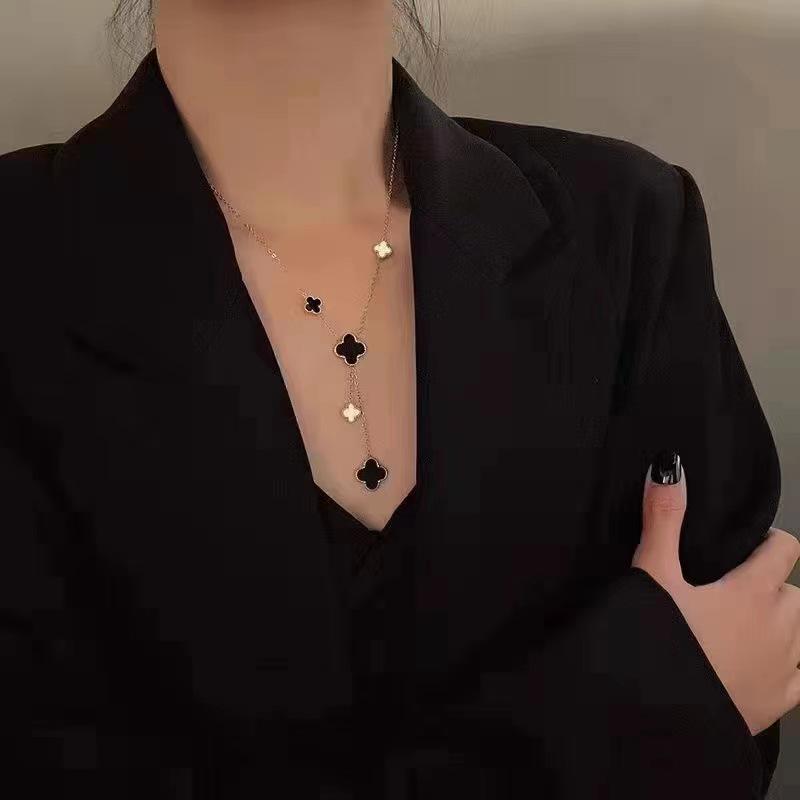 European & American Trendy Hollow Four-Leaf Clover Necklace with Black Shell Tassel Pendant.