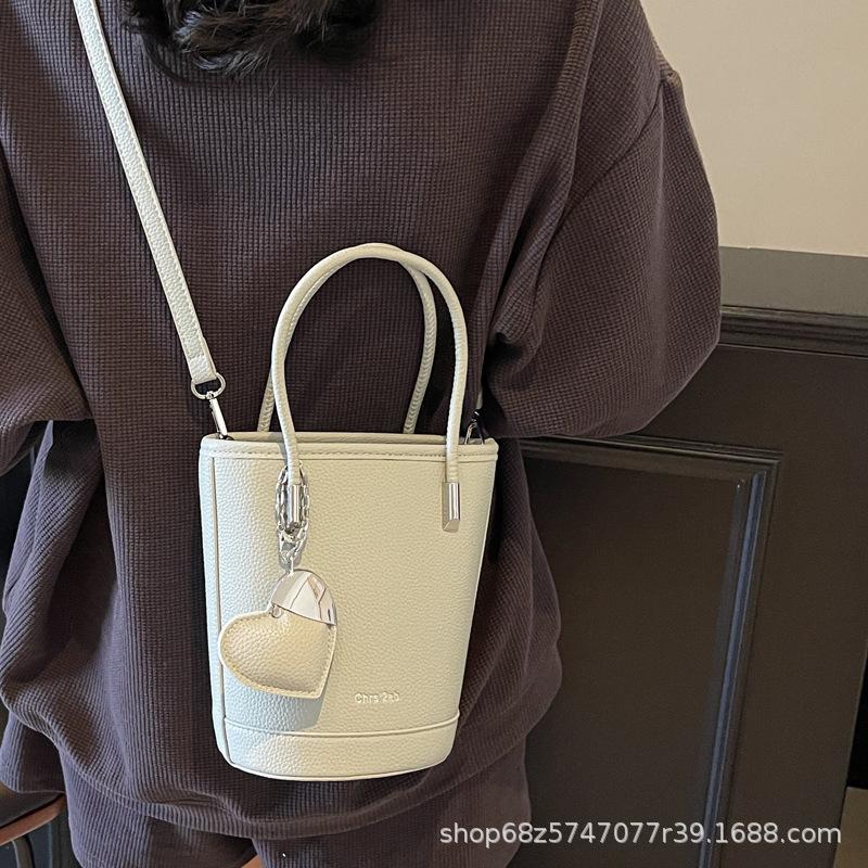 New niche simple solid color lychee pattern texture hand carrying bucket bag versatile foreign style commuting messenger women's bag