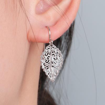 Pendientes chapados en oro con colgante de hoja hueca de moda, estilo retro de nicho y alta gama.
