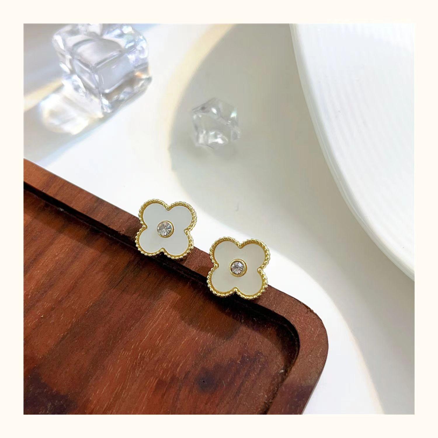 

Старшее чувство красочного четырехлистного клевера с бриллиантовыми серьгами. Изысканные модные темпераментные женские серьги с цветами. белый