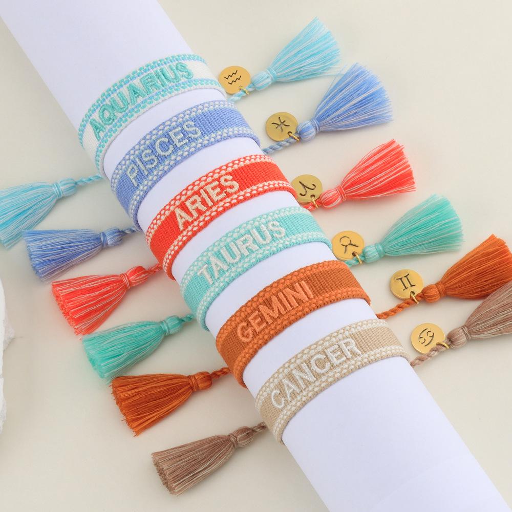 Kreuz Zwölf Sternzeichen Armband: Personalisierte handgefertigte geflochtene Kordel mit bestickten Buchstaben und Sternbild-Anhänger.