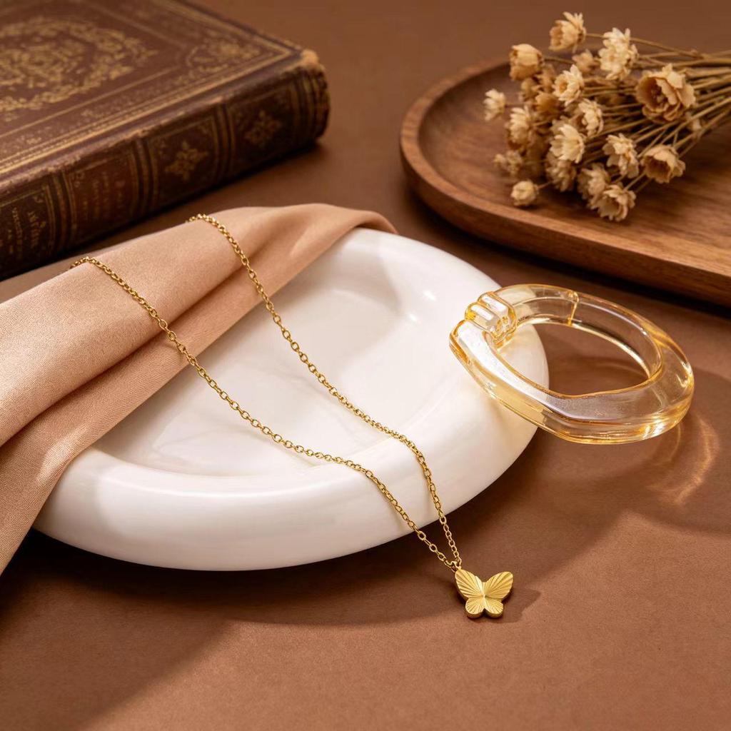 Gold Plated Titanium Steel Jewelry Set with Butterfly Carving: Necklace, Bracelet, and Earrings.