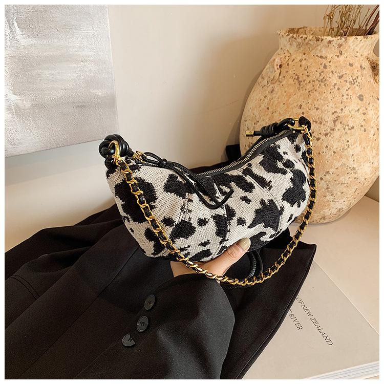 

Сумка с коровьим принтом женская большой вместимости новая осенне-зимняя нишевая повседневная на одно плечо через плечо для通勤 сумка-пельмень чёрный