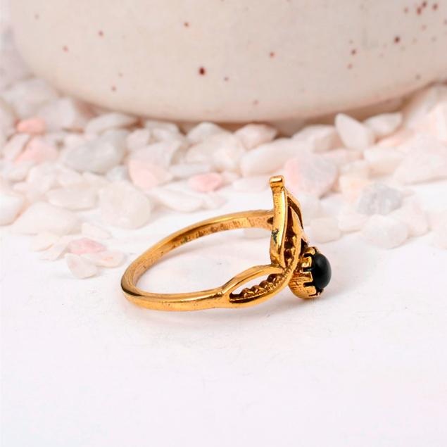 Ornate Black Onyx Crown Ring: Gold-toned jewelry with a round black cabochon and a delicate lotus or tiara-style setting.