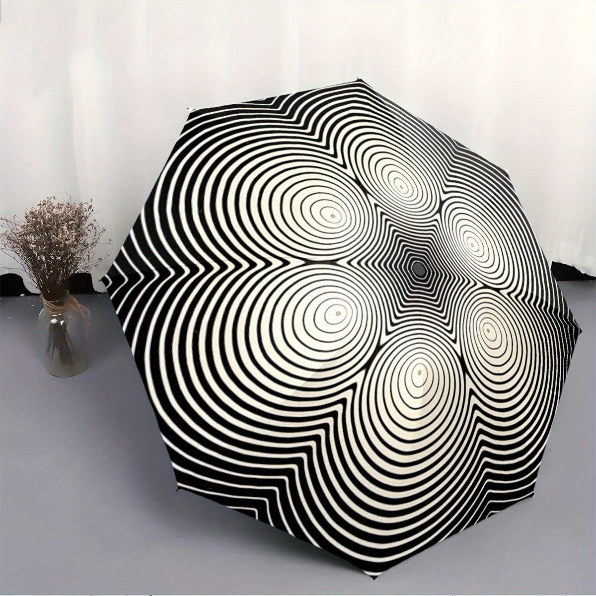 

Folding Umbrella The umbrella features a black and white concentric circle optical illusion pattern. Fits Travel, Backpack, Ho
